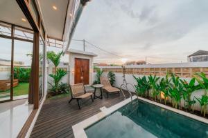 a house with a swimming pool and a patio at Villa Gadang in Kerobokan