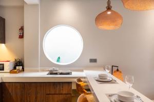 eine Küche mit einem ovalen Fenster und einem Tisch mit Stühlen in der Unterkunft Baliris Home Boutique Legian in Seminyak