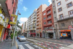 a city street with buildings and a car on the road at Habitación en el centro con Baño in Santa Cruz de Tenerife