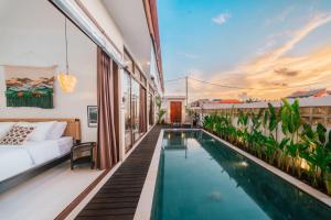 a villa with a swimming pool on a balcony at Villa Gadang in Kerobokan