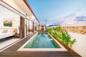 a swimming pool on the balcony of a house at Villa Gadang in Kerobokan