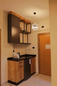 a kitchen with a sink and a black refrigerator at Al Jawhara Hotel Suites in Amman