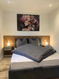 ein Schlafzimmer mit einem Bett und einem Gemälde an der Wand in der Unterkunft Seeferienhaus am Süßen See 