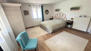 Un dormitorio con una cama y una silla azul. en Sous Le Tilleul - 3 personnes, en Valréas
