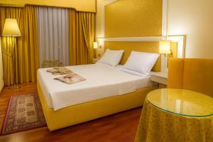 a hotel room with a large bed and a table at LVG Hotel Collection - La Bussola in Novara
