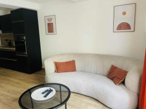 un soggiorno con un divano e un tavolo di vetro di Studio Bohème a La Côte-Saint-André