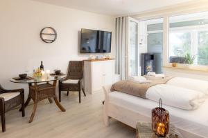 une chambre avec un lit, une table et une télévision dans l'établissement Harzliebe, à Sankt-Andreasberg