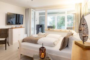 une chambre avec un grand lit et une fenêtre dans l'établissement Harzliebe, à Sankt-Andreasberg