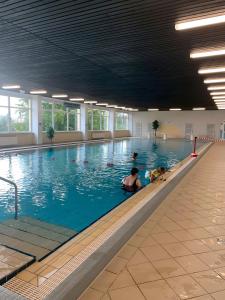 - une piscine avec 2 personnes dans l'eau dans l'établissement Geißenblick, à Hohegeiss