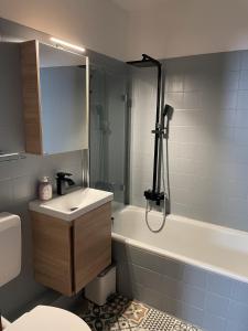 La salle de bains est pourvue d'une baignoire blanche, d'un lavabo et d'une baignoire. dans l'établissement Geißenblick, à Hohegeiss