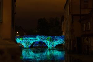 un ponte blu sopra un fiume di notte di Appartement charmant de 50m2 proche cathédrale a Chartres