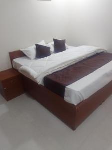 un letto grande con lenzuola e cuscini bianchi di Mayura palace a Jaipur Altre 2 foto