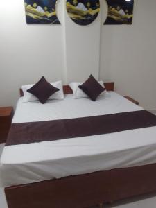 un grande letto con lenzuola e cuscini bianchi e neri di Mayura palace a Jaipur