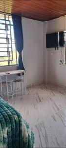 a room with a bed and a table and a window at Mirador del Molino in Fusagasuga