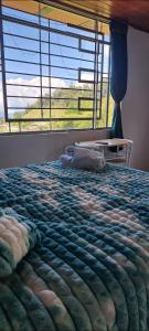 a bedroom with a bed with a large window at Mirador del Molino in Fusagasuga