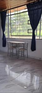 a table and chairs in a room with a window at Mirador del Molino in Fusagasuga