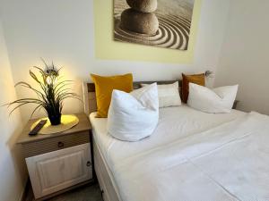 a bedroom with a bed with white sheets and pillows at KÄPT´N BRASS "Kajüte 4" in Dierhagen