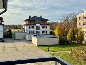a large white house with two garages in front of it at KÄPT´N BRASS "Kajüte 4" in Dierhagen