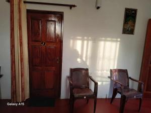 two chairs sitting in a room with a door at Kumari villa in Weligama +4 photos