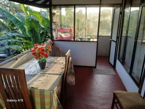 a porch with a table with flowers on it at Kumari villa in Weligama