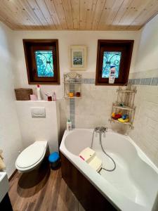 een badkamer met toilet en ligbad bij Chalet Etienne in Jarrier +23 foto's