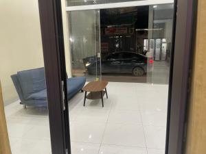 eine Glastür, dahinter ein blaues Sofa und ein Tisch in der Unterkunft Căn Hộ Phương Anh in Thanh Hóa
