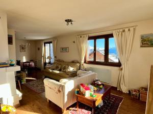 een woonkamer met een bank en een tafel bij Chalet Etienne in Jarrier