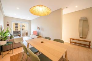 a living room with a wooden table and chairs at GuestReady-Charming Coastal Getaway in Almada