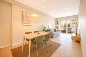 a living room with a wooden table and chairs at GuestReady-Charming Coastal Getaway in Almada