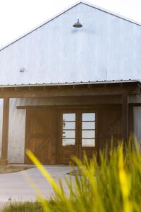 a barn with wooden doors and a white roof at Bent Oak Highland Ranch and Concierge Services in Burnet +48 photos