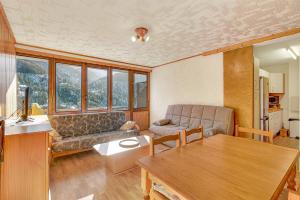 una sala de estar con un sofá y una mesa en Orciéres Village, en Orcières