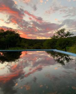 een plas water met een bewolkte lucht bij zonsondergang bij La Pasionaria, casa de campo con pileta in Villa García