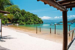 Angra Beach Hotel في انغرا دوس ريس: شاطئ به نخيل والمحيط