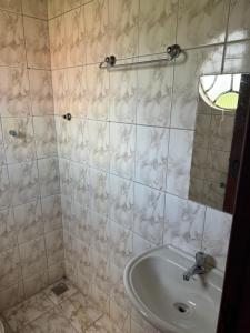 a bathroom with a sink and a mirror at Pousada Cachoeira in Itambé do Mato Dentro
