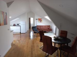a living room with a couch and a table and chairs at Ares do mar - Loft and terrace in Matosinhos