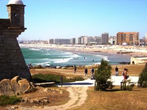 a view of a beach with people in the water at Ares do mar - Loft and terrace in Matosinhos