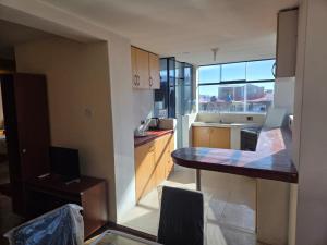 eine Küche mit Tisch und Arbeitsplatte in der Unterkunft Apartamento centrico en Puno in Puno