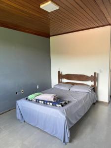 a bed in a bedroom with a wooden ceiling at Pousada Cachoeira in Itambé do Mato Dentro
