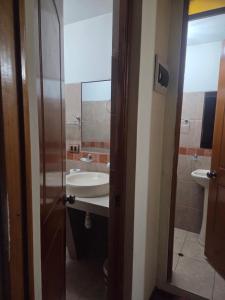 ein Badezimmer mit Waschbecken und Spiegel in der Unterkunft Apartamento centrico en Puno in Puno