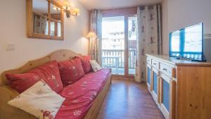 ein Wohnzimmer mit Sofa und Fernseher in der Unterkunft T Bergerie A N104 2P4 in Forest des Baniols