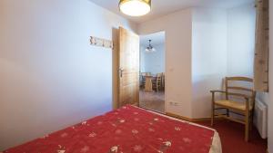 ein Schlafzimmer mit einem Bett, einem Stuhl und einem Tisch in der Unterkunft T Bergerie A N104 2P4 in Forest des Baniols + 4 Fotos