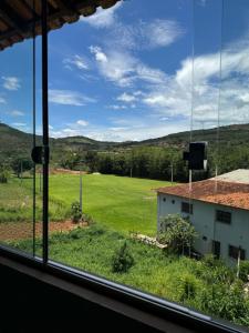 a view of a field from a window at Pousada Cachoeira in Itambé do Mato Dentro