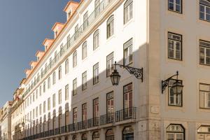 ein großes weißes Gebäude mit Fenstern und einem Balkon in der Unterkunft MYTHIC SANA Downtown Suites in Lissabon
