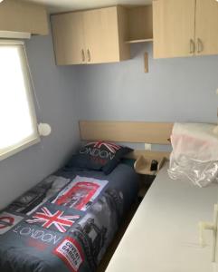 a small room with a bed and a window at L'Aurore - Mobil-home climatisé - Piscine in La Bernerie-en-Retz +16 photos