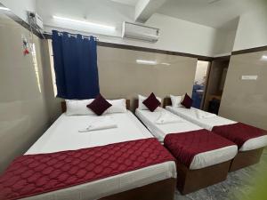 two beds in a room with red and white at Hotel Anbu Airport in Chennai +23 photos