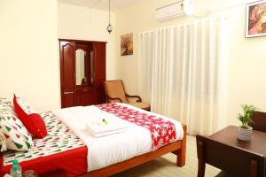 a bedroom with a bed with a red and white blanket at Casa maryam in Fort Kochi