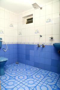 a blue bathroom with a toilet and a sink at Casa maryam in Fort Kochi