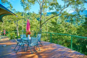 a table and chairs on a deck with a umbrella at Manoas in Uvita