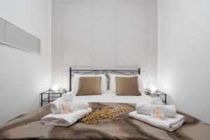 a bedroom with a bed with white sheets and gold pillows at St Mark's Square - K Collection in Venice