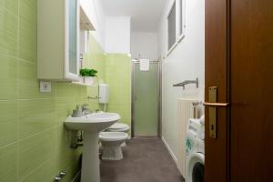 a green bathroom with a sink and a toilet at St Mark's Square - K Collection in Venice